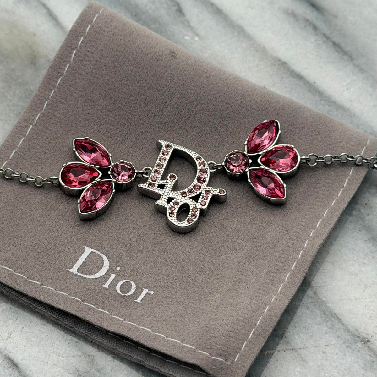 CHRISTIAN DIOR PINK CRYSTAL LOGO BUTTERFLY BRACELET