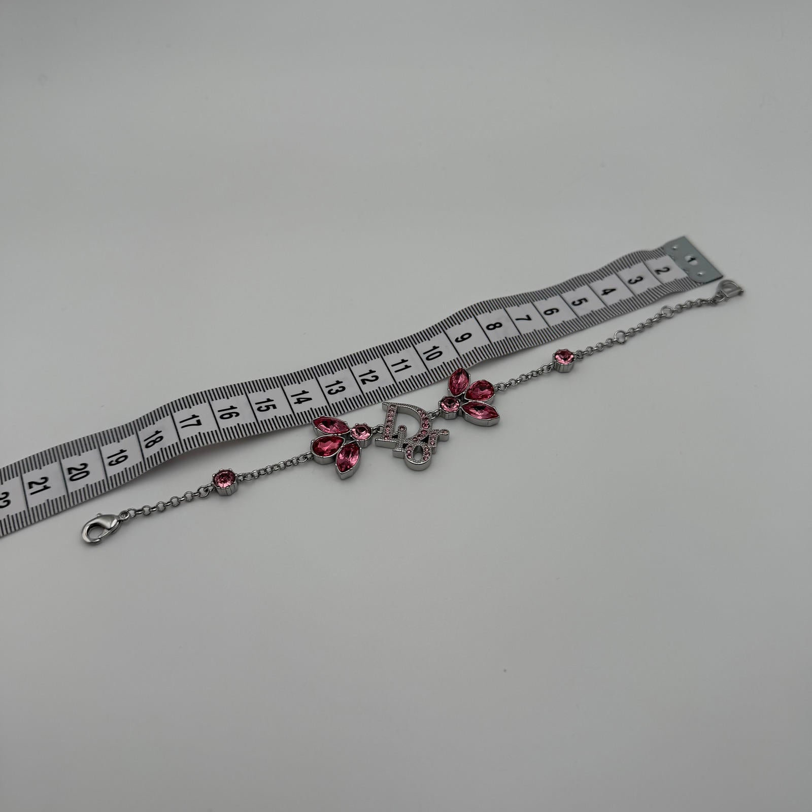 CHRISTIAN DIOR PINK CRYSTAL LOGO BUTTERFLY BRACELET