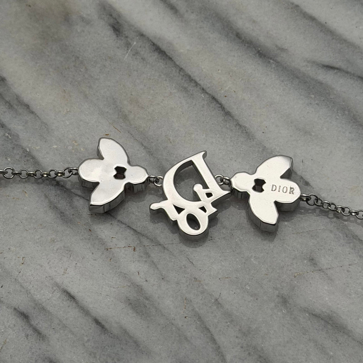 CHRISTIAN DIOR PINK CRYSTAL LOGO BUTTERFLY BRACELET